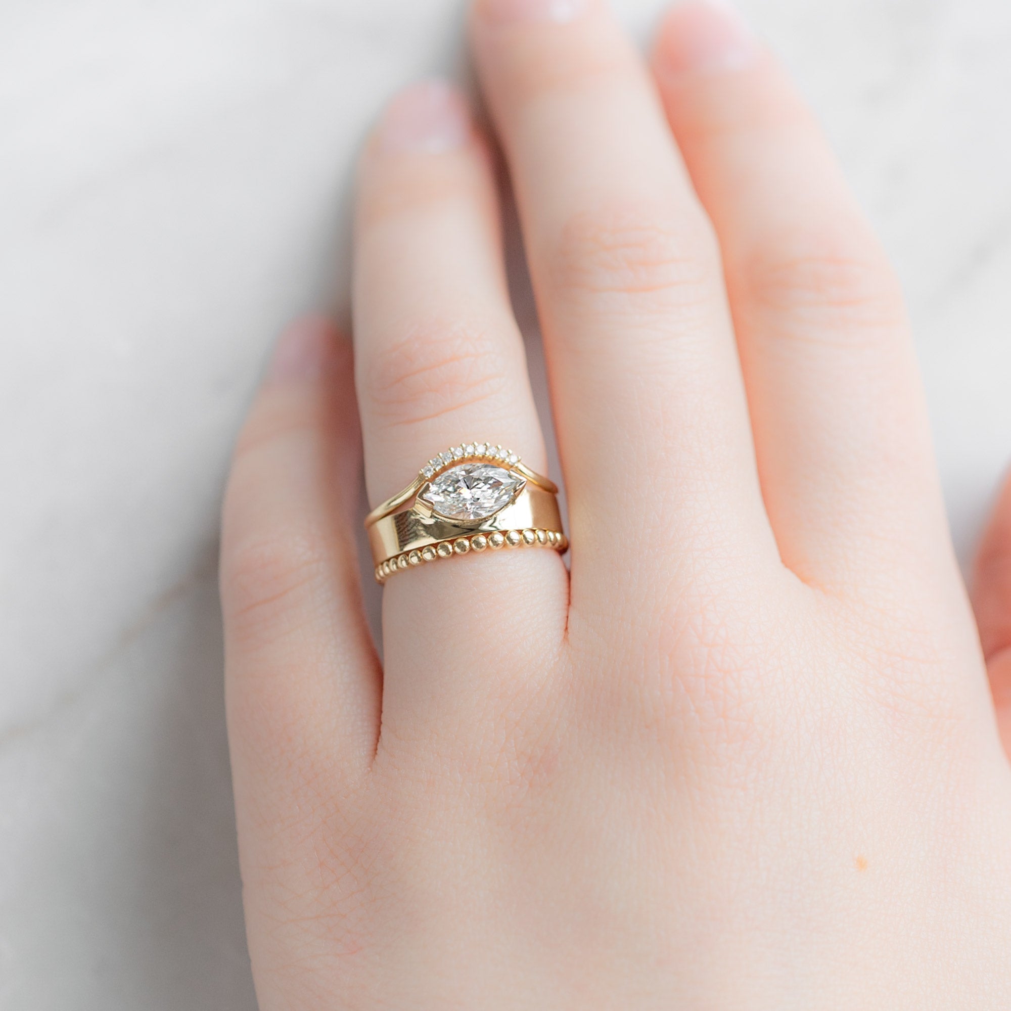 The Gold Beaded Stacking Ring in 14K Yellow Gold Stacked with White Diamond Engagement Ring on Model