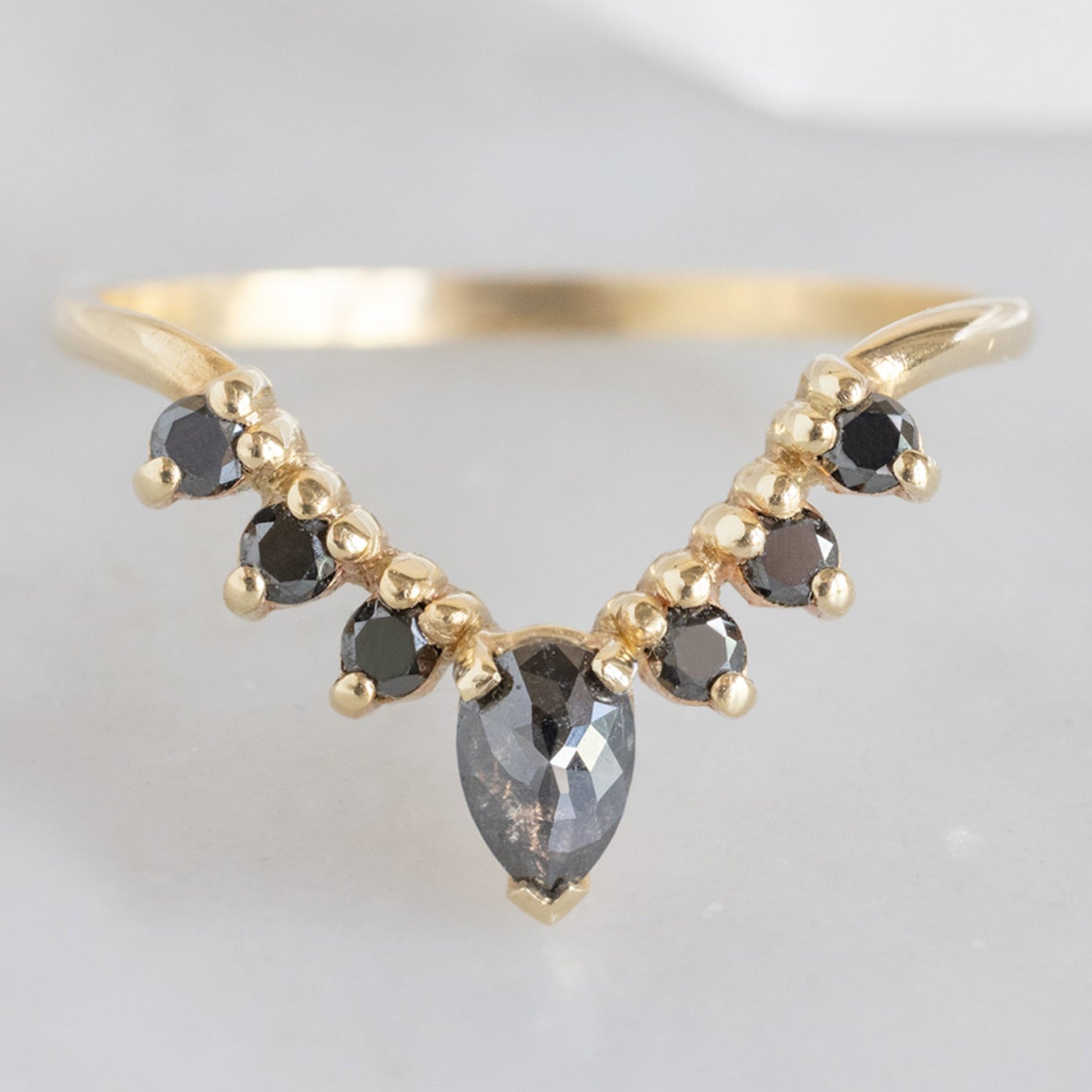 One of a Kind Pear Black Diamond Sunburst Stacking Band in 14K Yellow Gold on White Marble