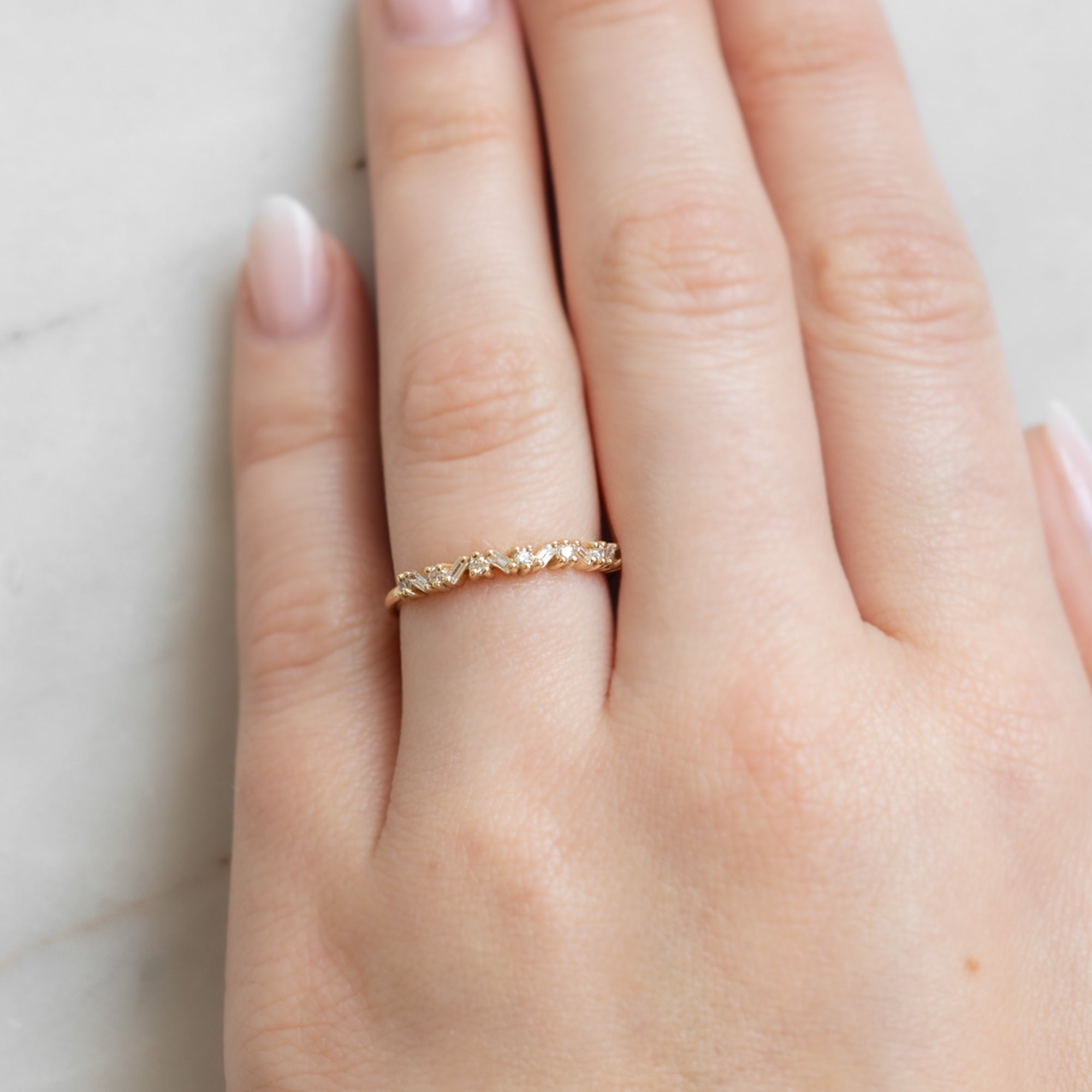 The Baguette Confetti Stacking Ring In Yellow Gold on Model's left hand ring finger