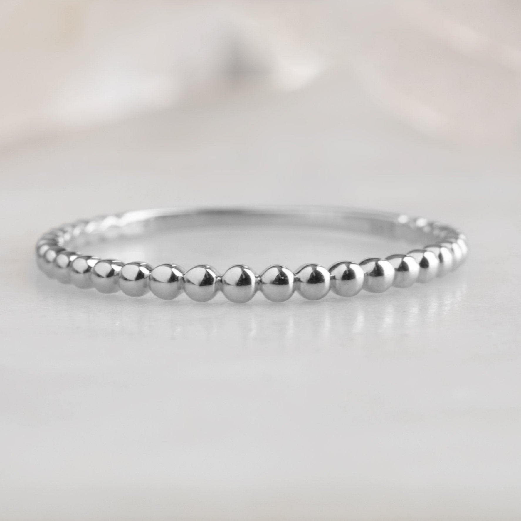 The Gold Beaded Stacking Ring in 14K White Gold on White Marble